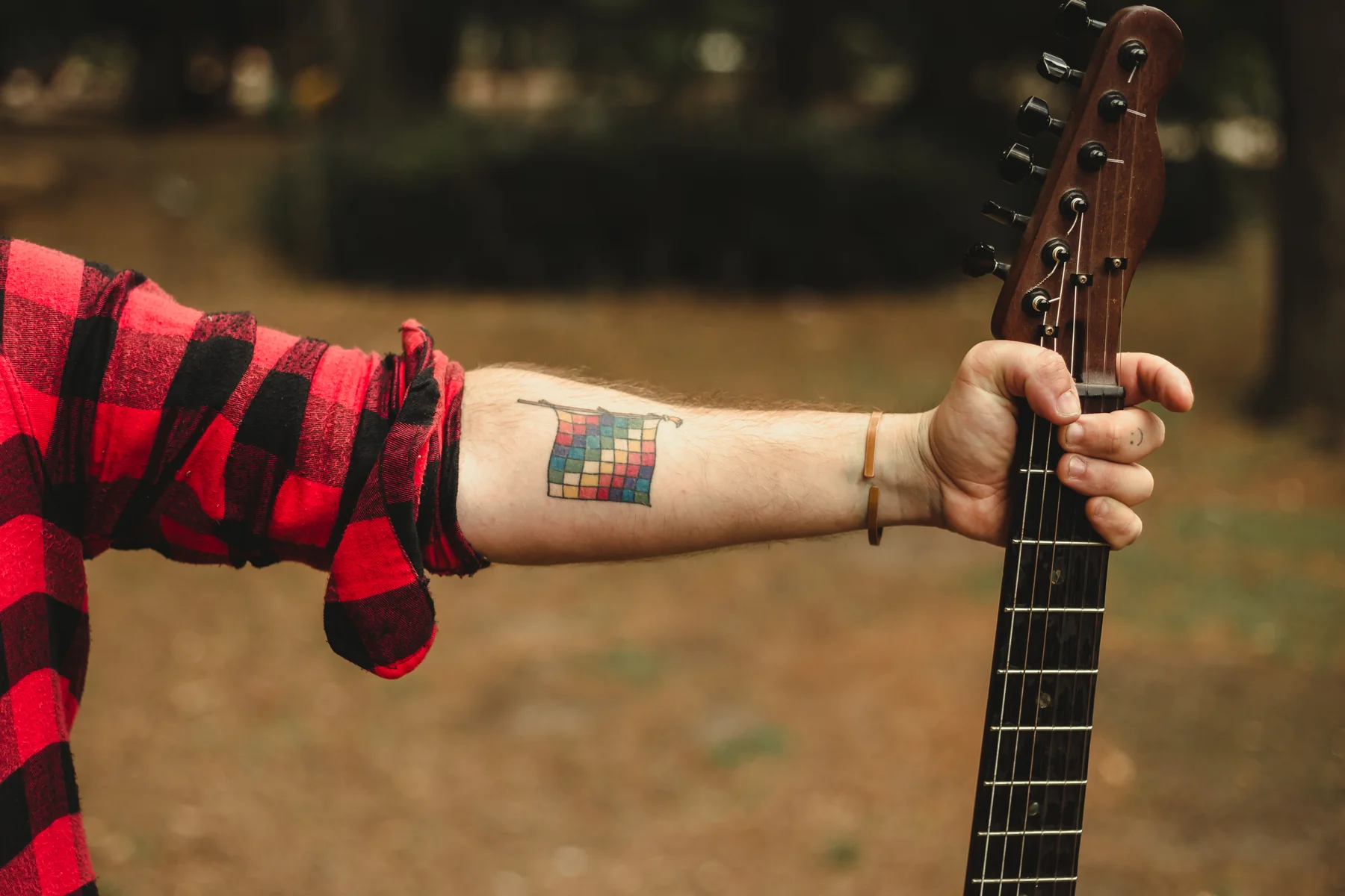 Detalle del tatuaje de Wiphala de Marquitos Folkis junto a una guitarra